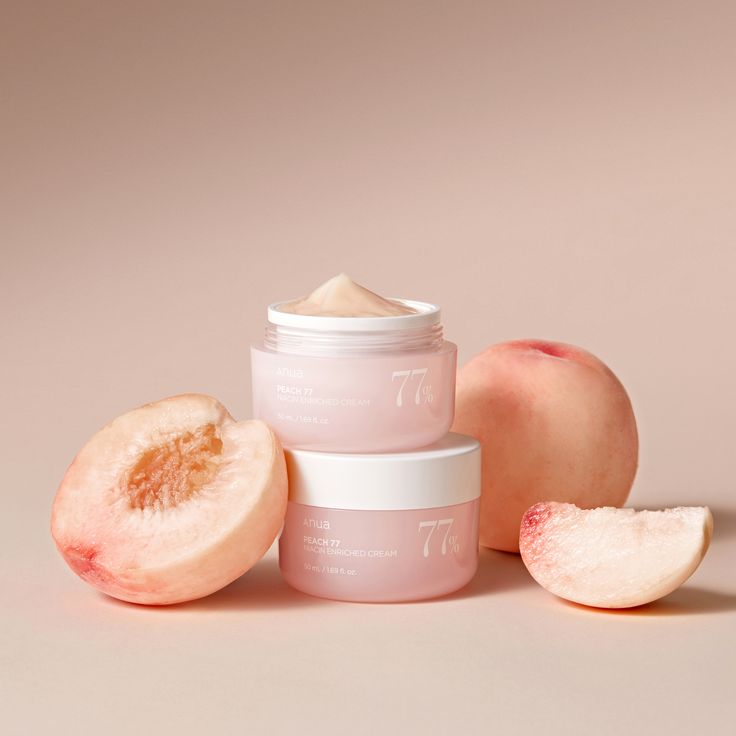 Two jars of skincare product with peaches on a beige background