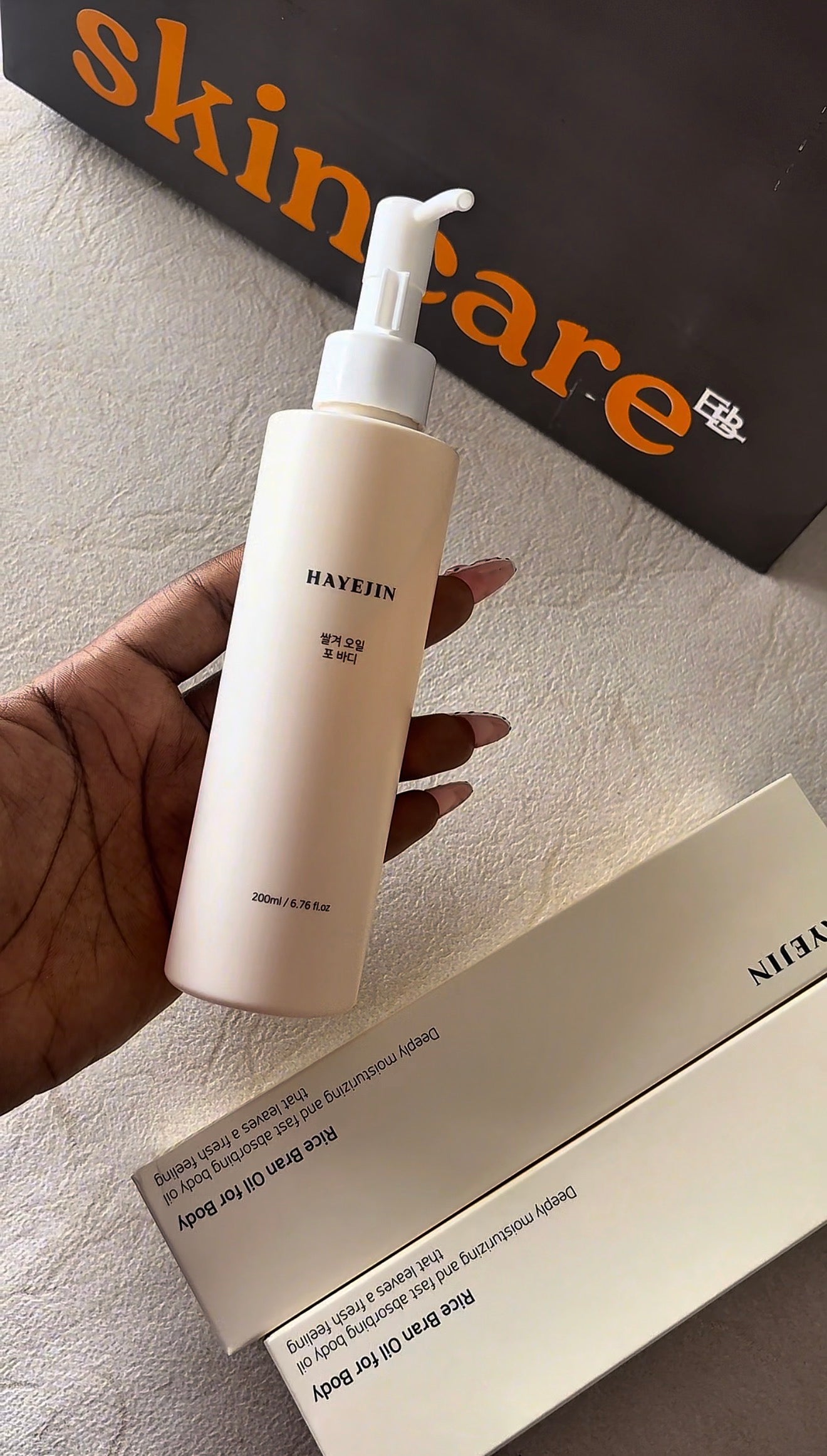 Skincare bottle held by a hand with 'skincare' branding in the background