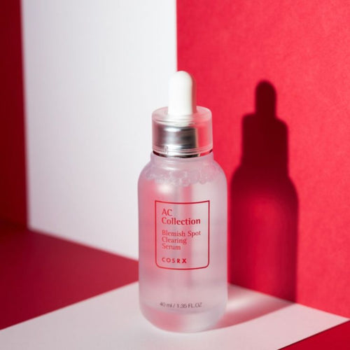 Cosrx AC Collection serum bottle with dropper on a red and white background