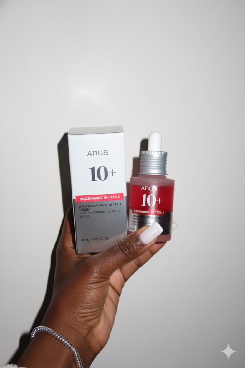 Hand holding a bottle and box of Anua 10+ skincare product against a plain background