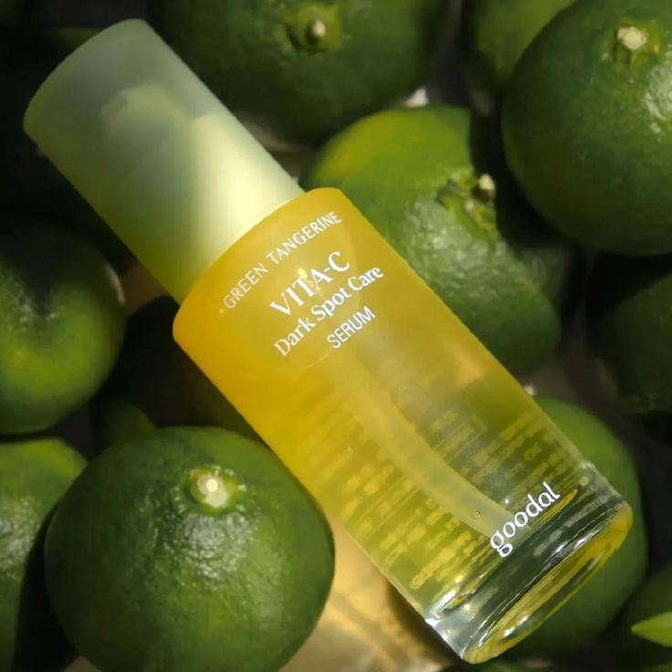 Serum bottle labeled 'Vita-C Dark Spot Care' surrounded by green tangerines