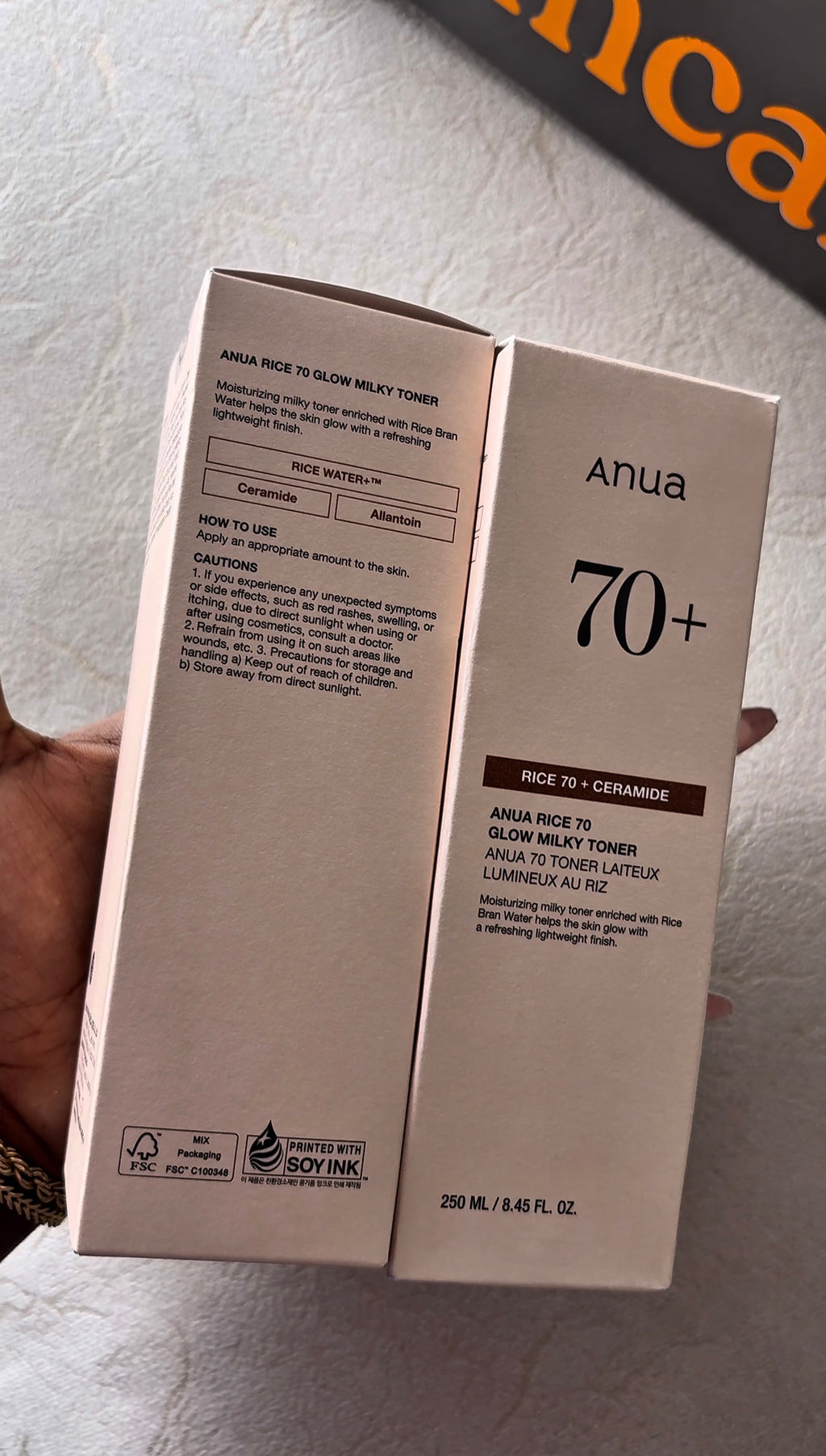 Two boxes of Anua 70+ skincare product on a light gray surface.