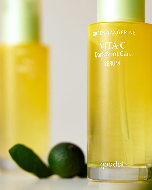 Goodal VITA-C Dark Spot Care Serum bottle with green tangerine leaves on a light background
